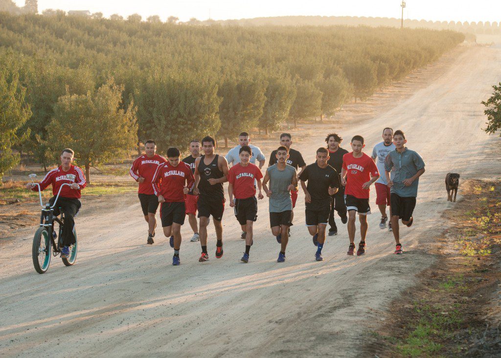 McFARLAND, USA..Coach Jim White on set w/ the real McFarland '87 runners and current cross country team runners...Ph: Ron Phillips..©Disney 2015